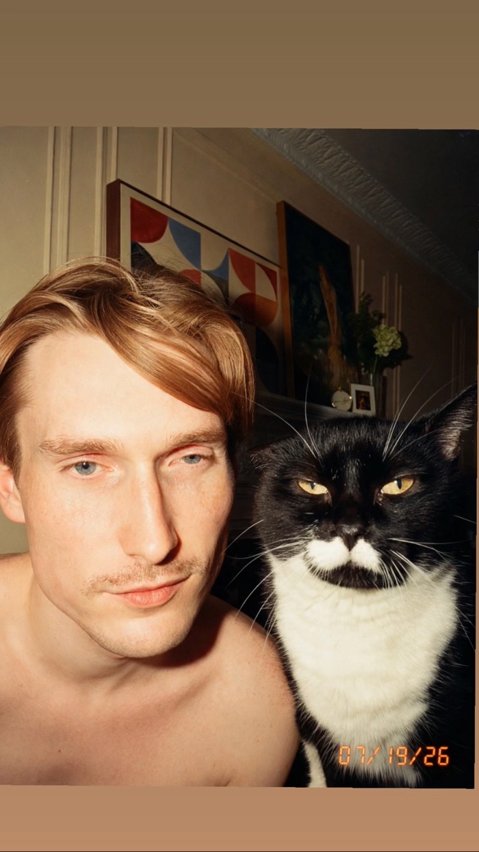 Cam shirtless with his unimpressed tuxedo cat